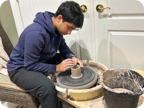 Sidh J throwing a pot on a wheel