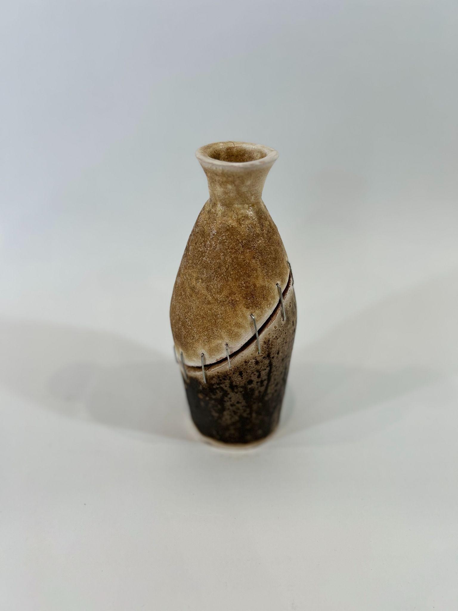 An obvara-fired vessel with a stitched seam across its shoulder