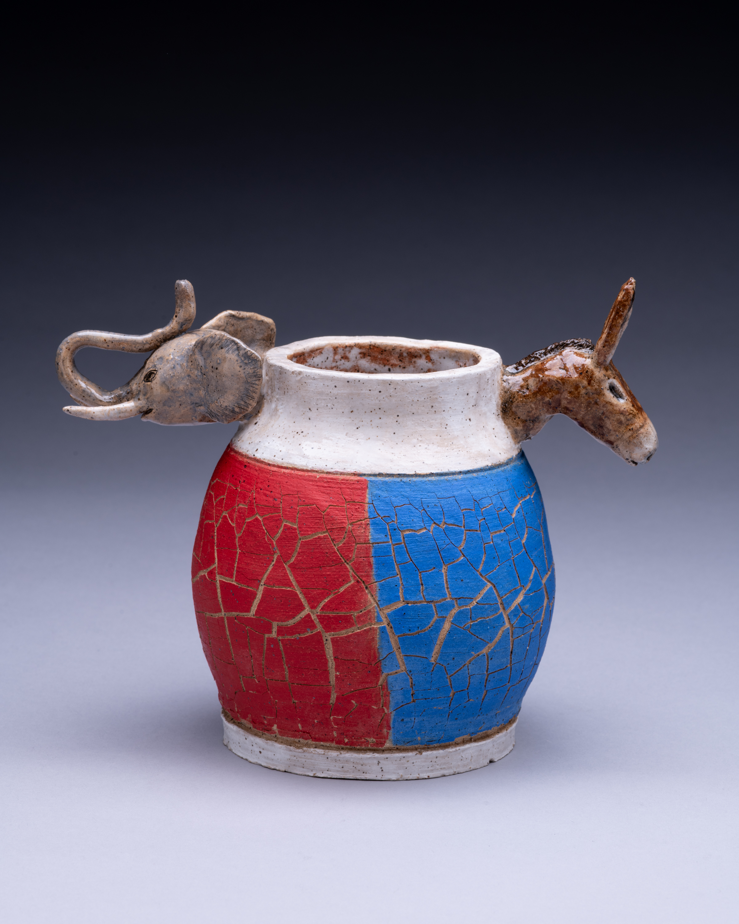 A crackle-glazed vessel split red and blue with a donkey and an elephant at its rim